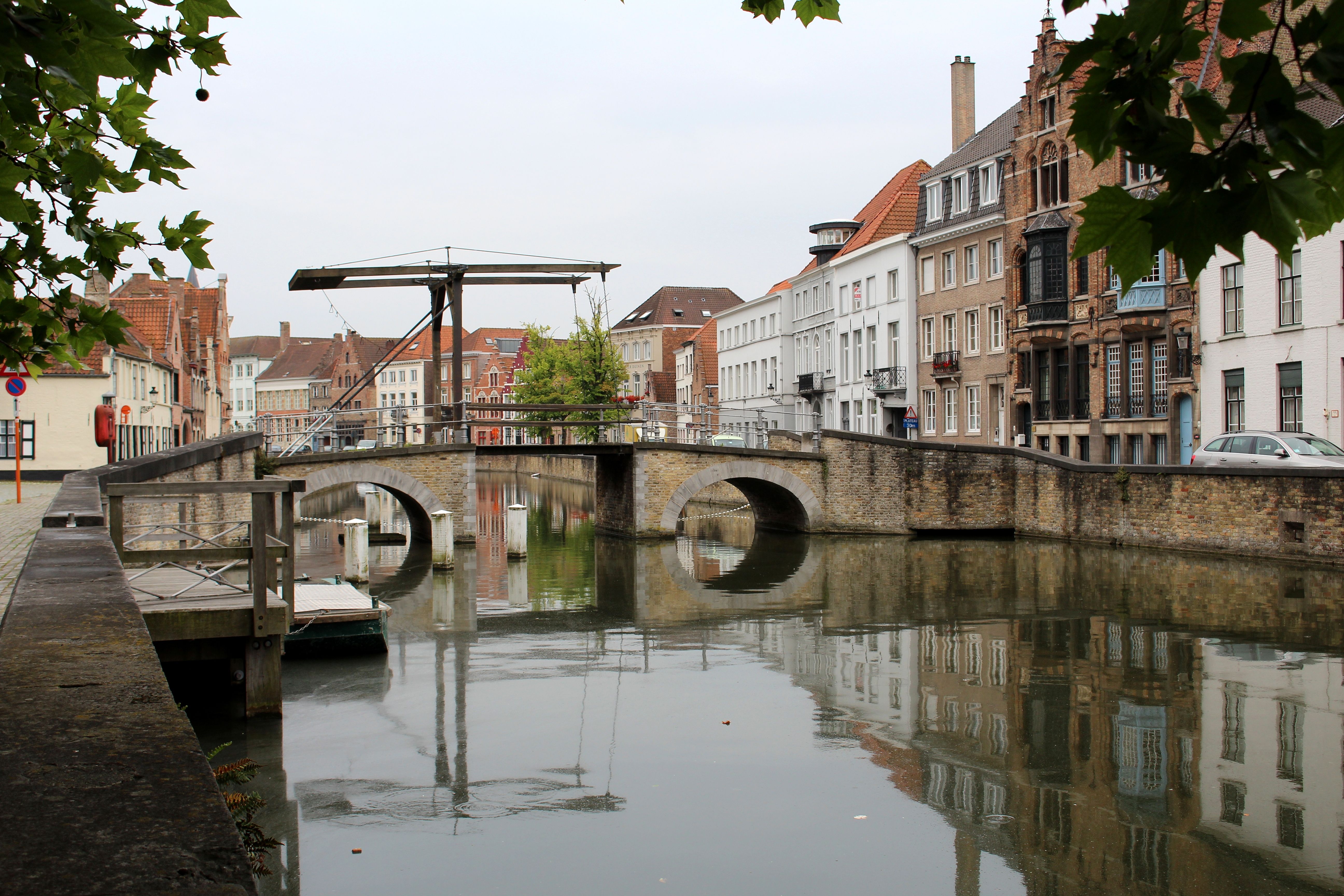 Picturesque view of a canal bridge in Bruges, lined with historic buildings.
