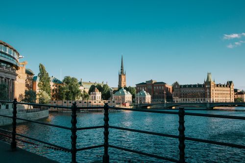 Free A picturesque view of Stockholm's Riddarholmen with blue skies and calm waters. Stock Photo