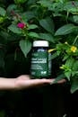 Herbal Supplement Bottle in Lush Garden Setting