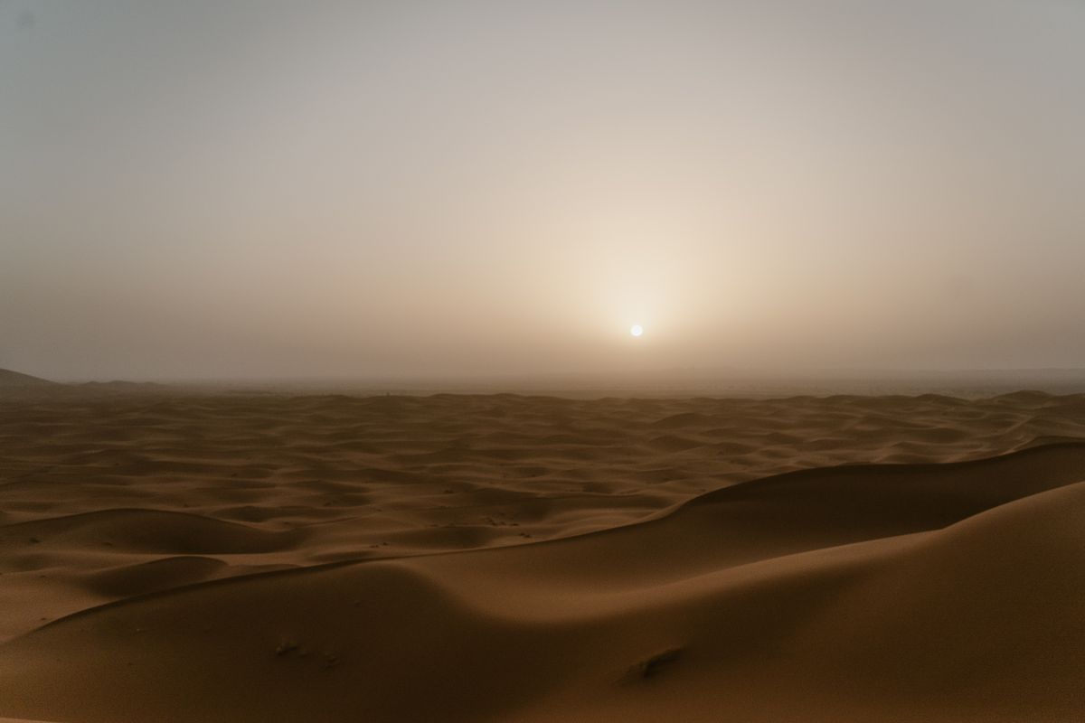 Dunes orangées du Sahara marocain au coucher du soleil