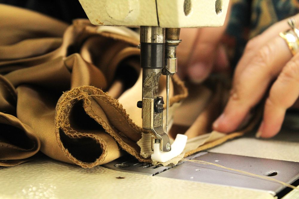 Hands sewing fabric with a sewing machine