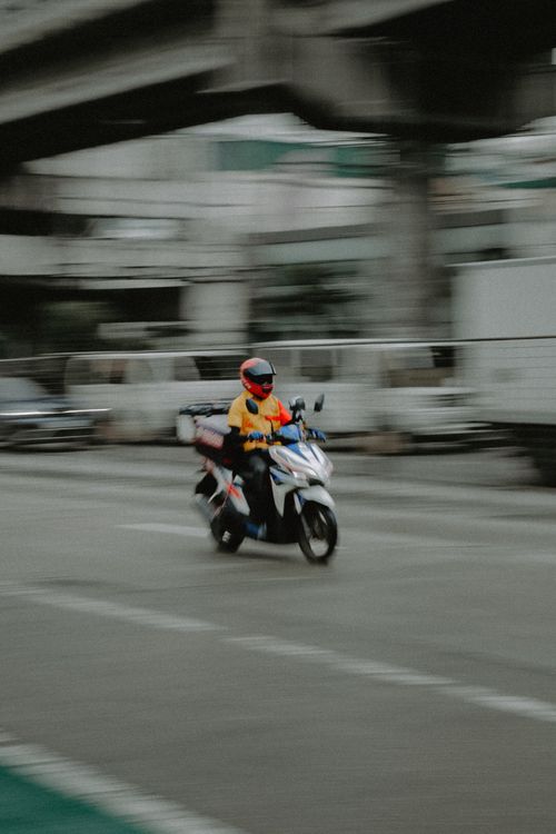 Free Vibrant panning shot of a scooter rider in Quezon City, Metro Manila. Stock Photo