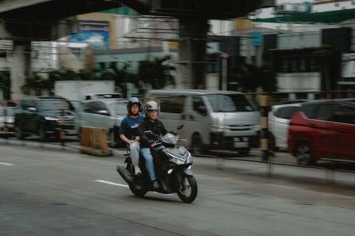 Free A motorcycle with two riders on a busy street in Quezon City, Metro Manila. Stock Photo