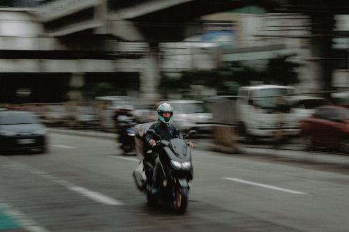 Free Blurred motion shot of a motorcyclist on a busy street in Quezon City, Philippines. Stock Photo