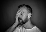 一位留着胡须的男子，其黑白肖像富有表现力，展现了压力与沉思