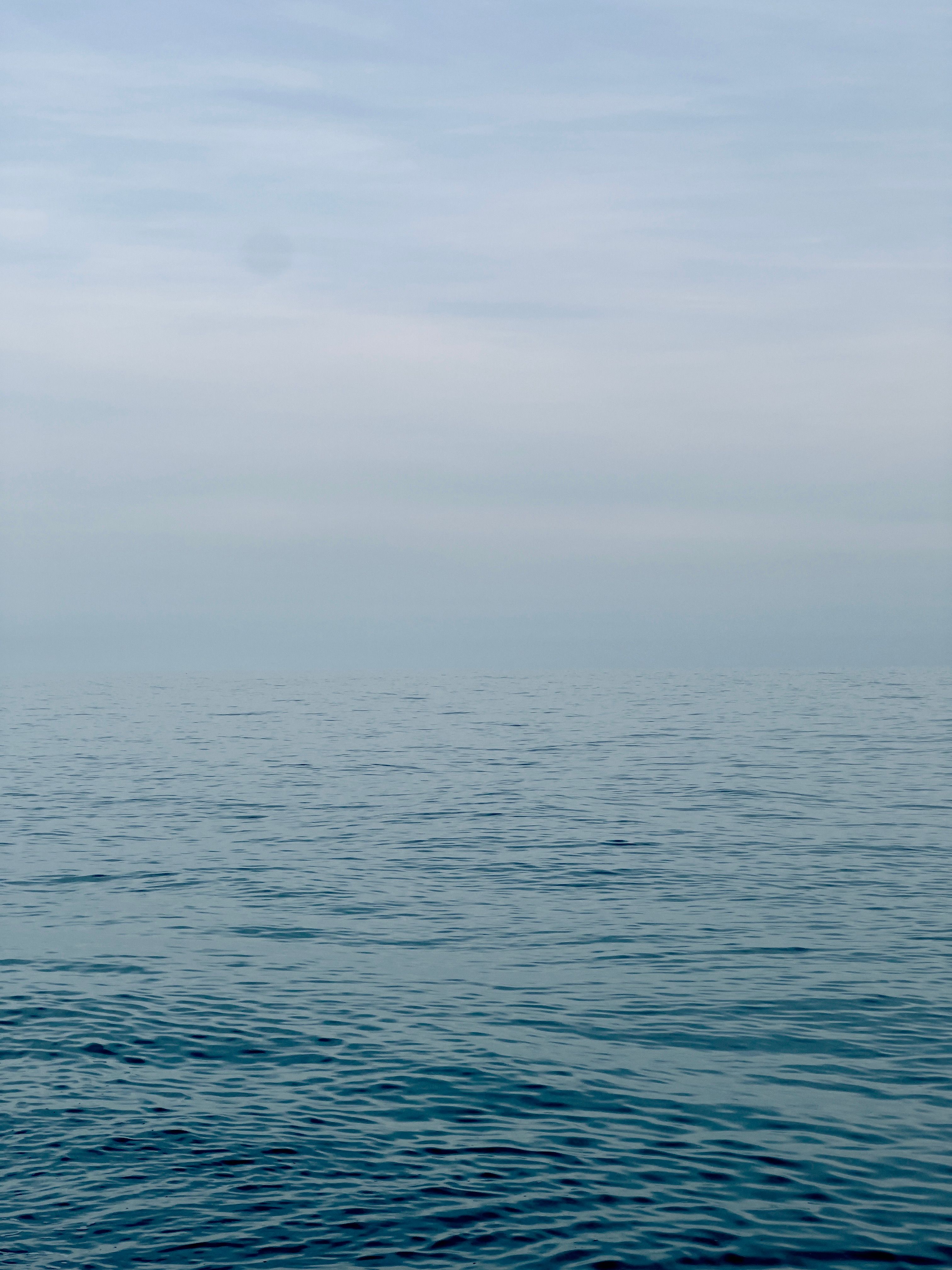 Calm Ocean Water Under a Cloudy Sky · Free Stock Photo