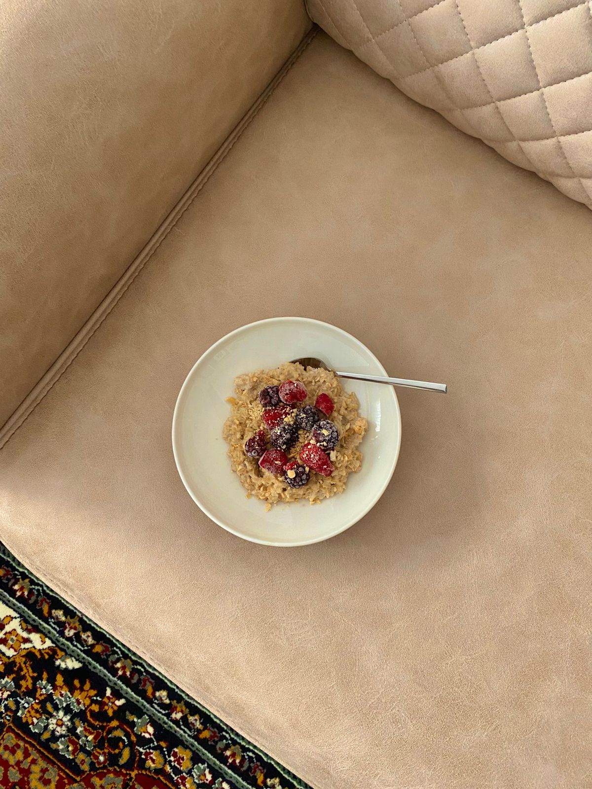 A cozy bowl of warm oatmeal topped with berries — a gentle, sleep-friendly evening snack.
