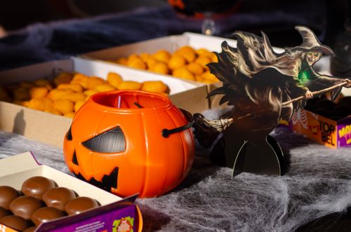 Free Festive Halloween candy arrangement with a pumpkin bucket and witch cutout. Stock Photo