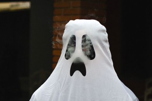 Free A spooky ghost costume with smoke effect for Halloween fun outdoors. Stock Photo