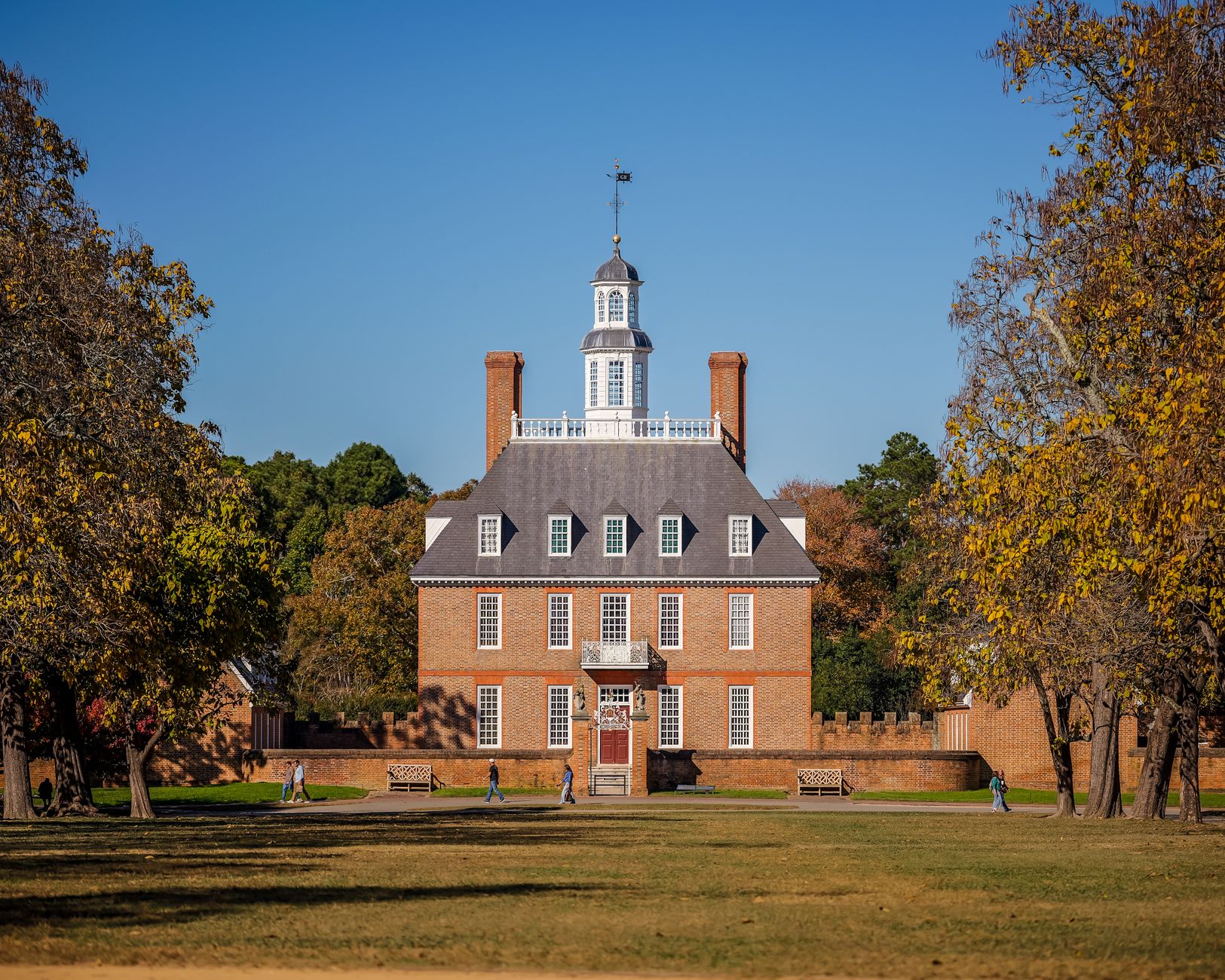 Historic Governor's Palace in Colonial Williamsburg surrounded by autumn foliage.