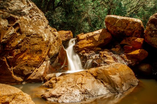 A tranquil waterfall flows over rocky terrain in Santa Maria, Brazil.