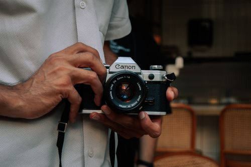 Free A person holding a classic Canon film camera, emphasizing retro photography. Stock Photo