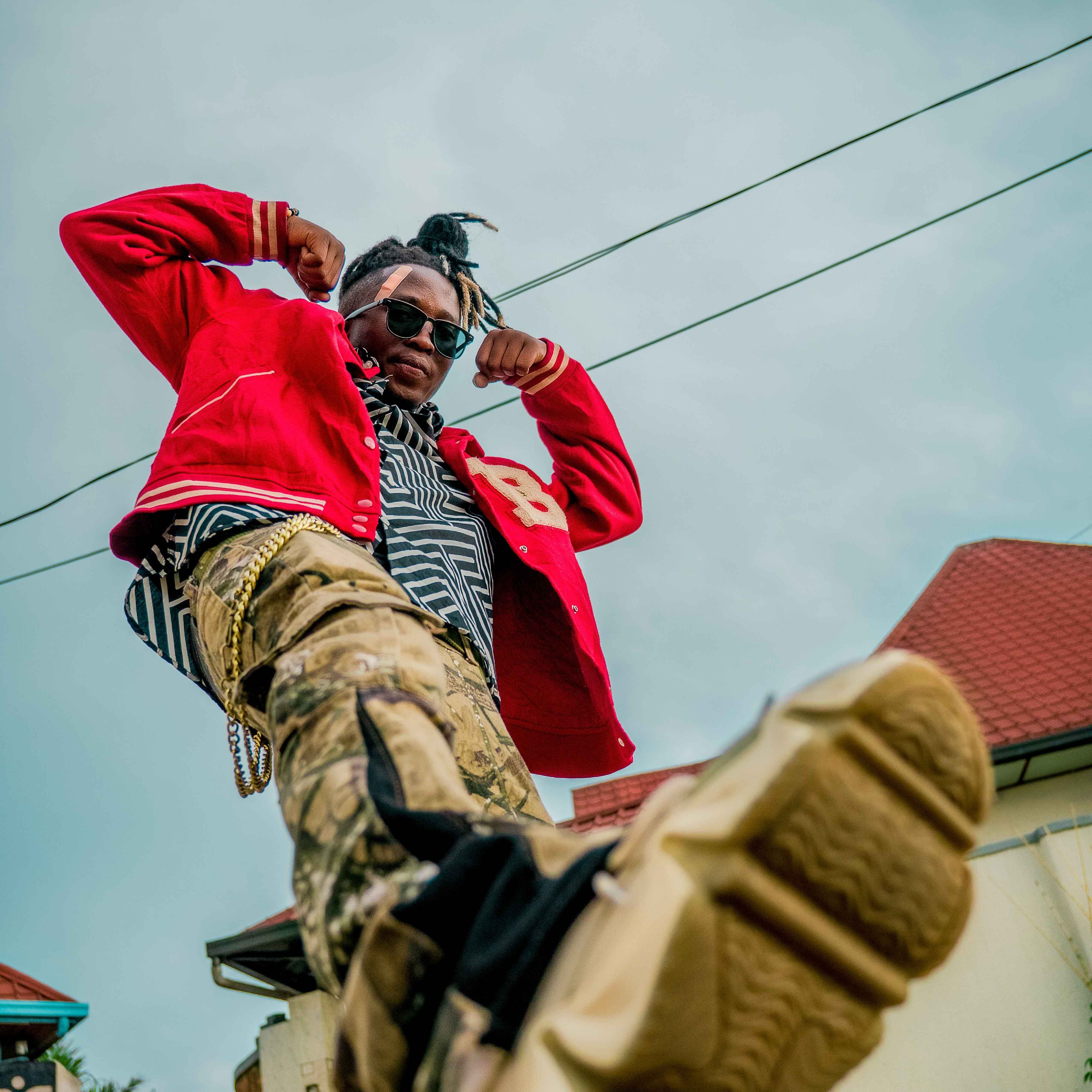 Low-angle street fashion photo of a person wearing red jacket and sunglasses.