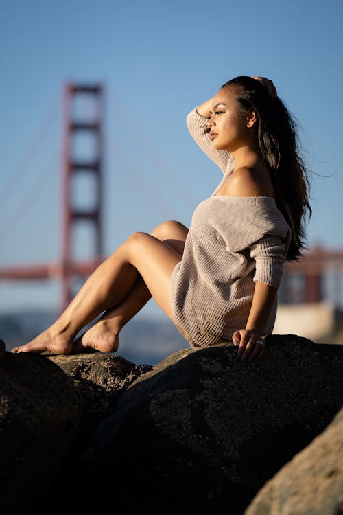 Woman Wearing Gray Sweater Sitting on Rock