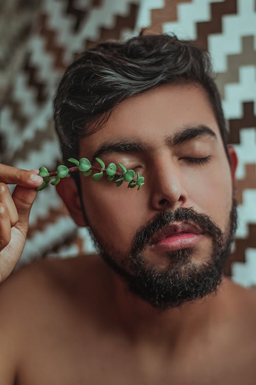 Um Homem Segura Uma Folha Suculenta Sobre O Olho Fechado