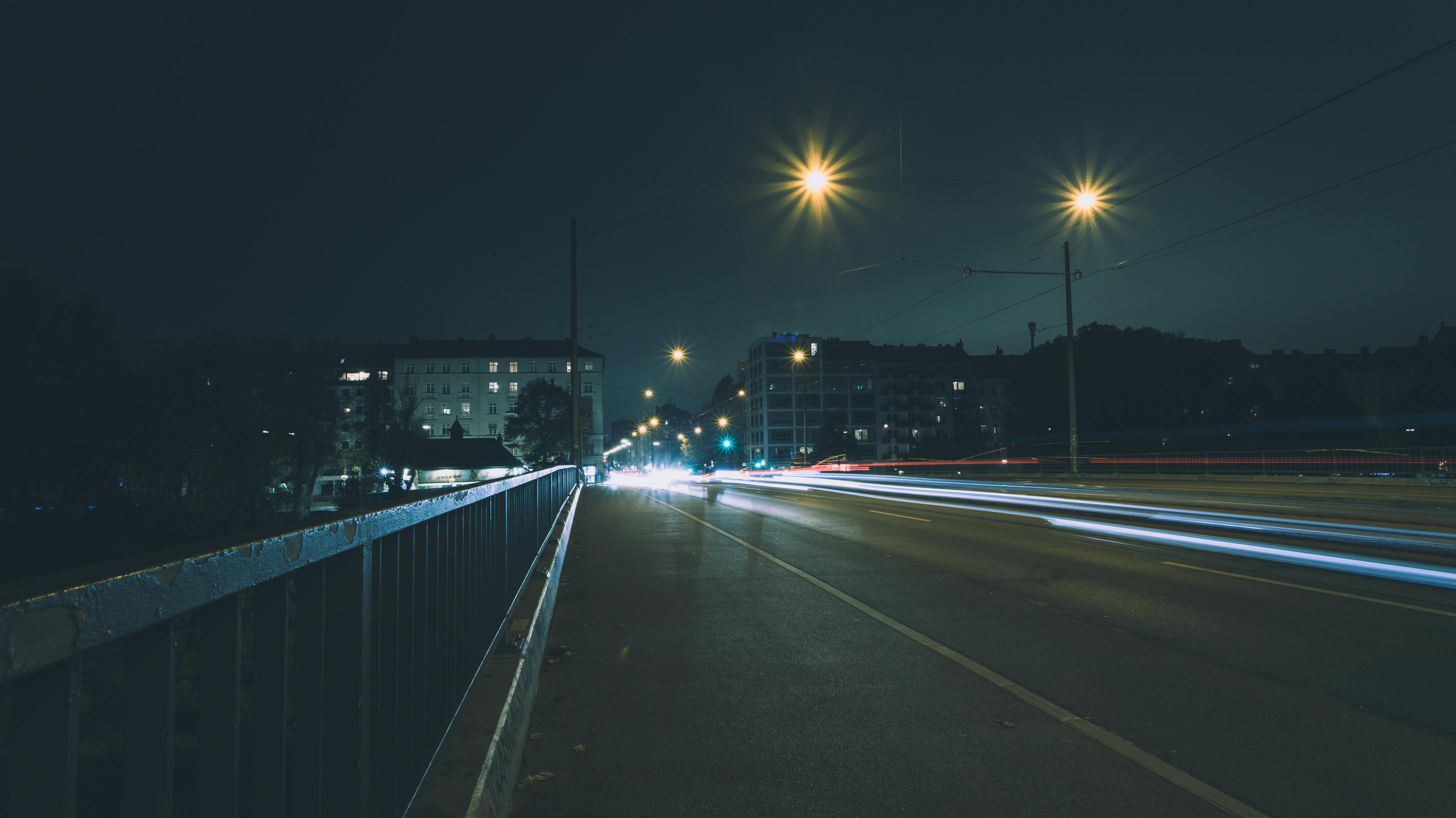 Night view of a street in Munich showcasing light trails from cars and illuminated streetlights.