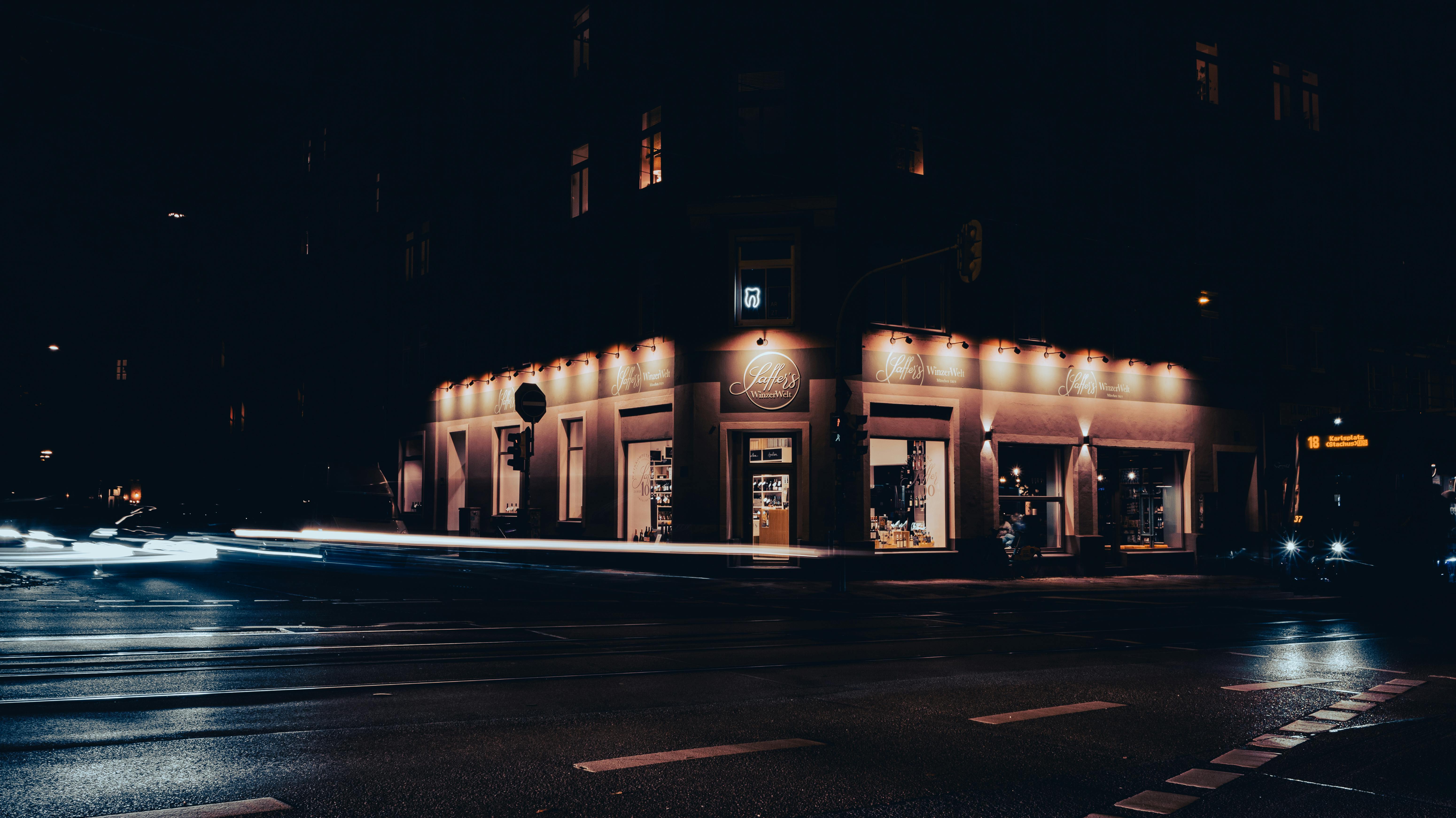 Captivating nighttime view of a Munich street corner with light trails and illuminated storefronts.