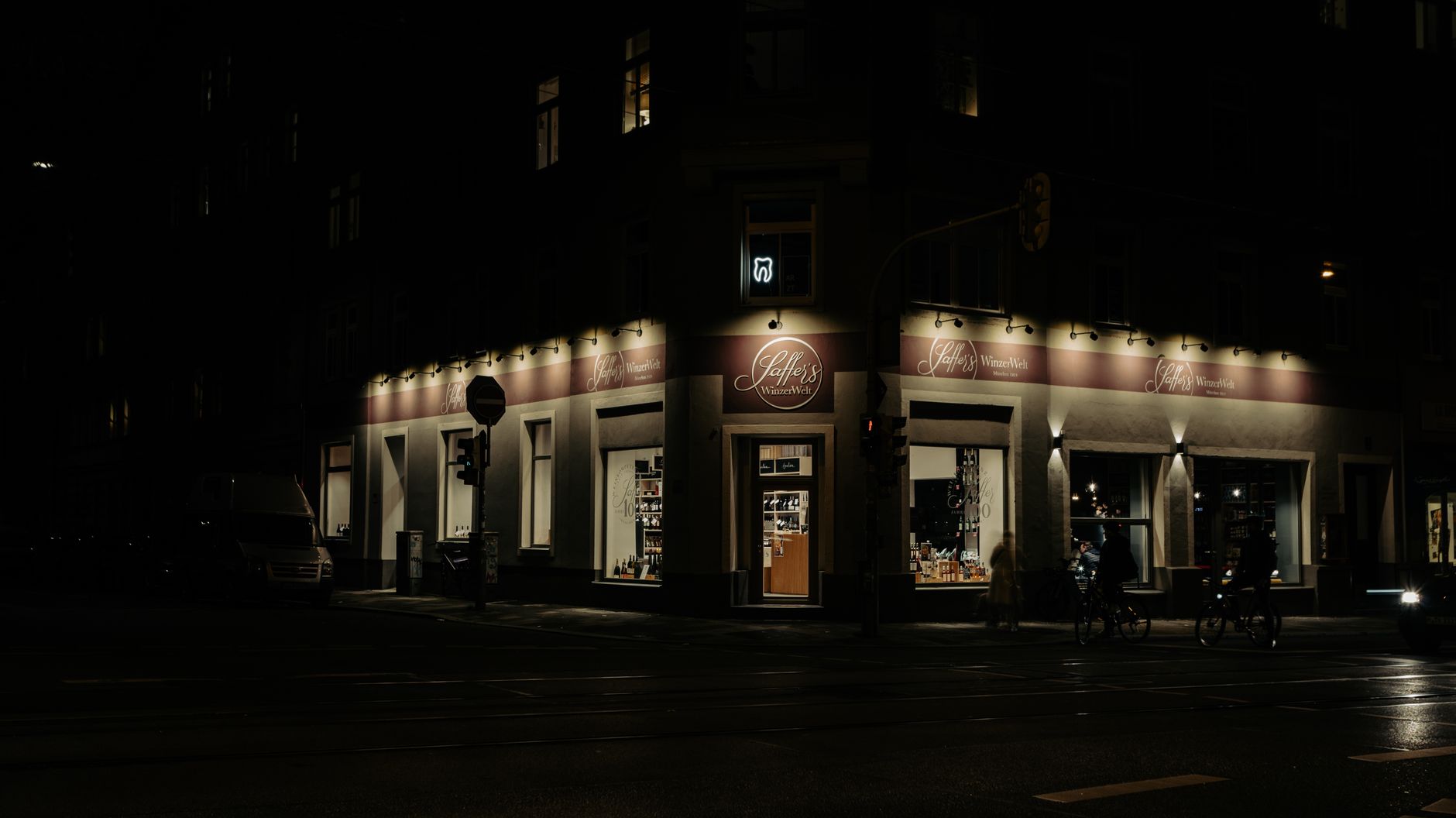 Dimly lit shopfront in Munich at night, showcasing urban nightlife and architecture.