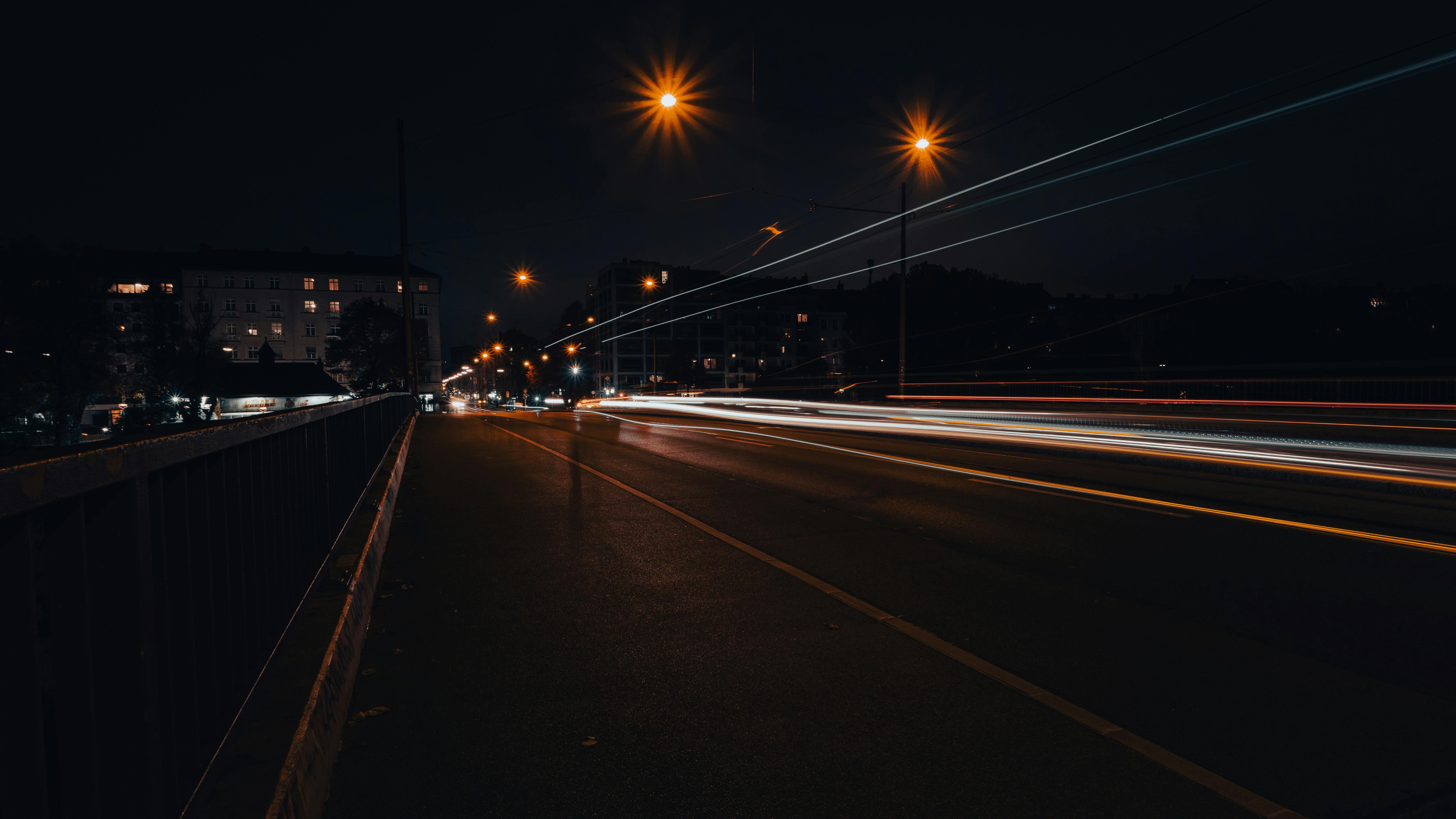 Vibrant light trails on a Munich street at night, showcasing city life.