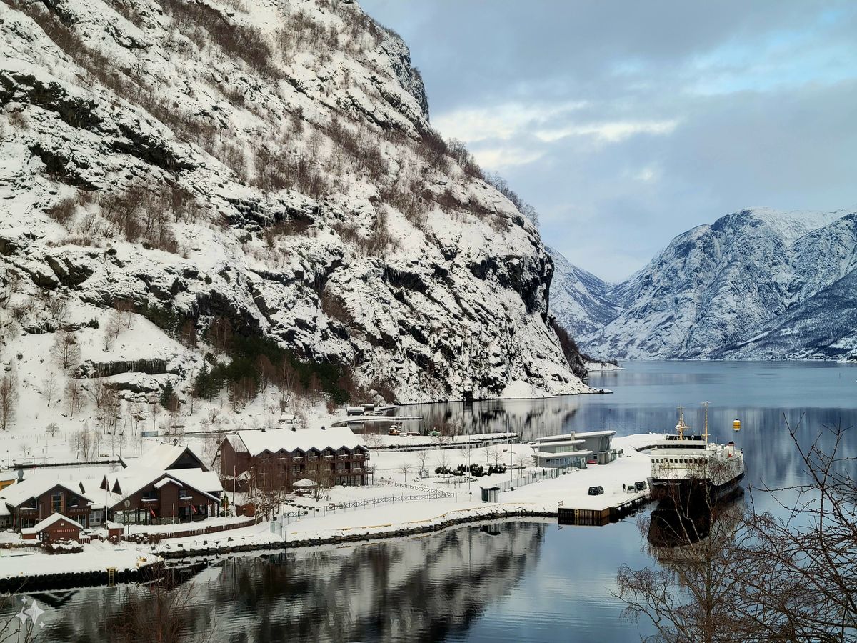Snow-covered port in Flam Norway with mountain reflections in winter