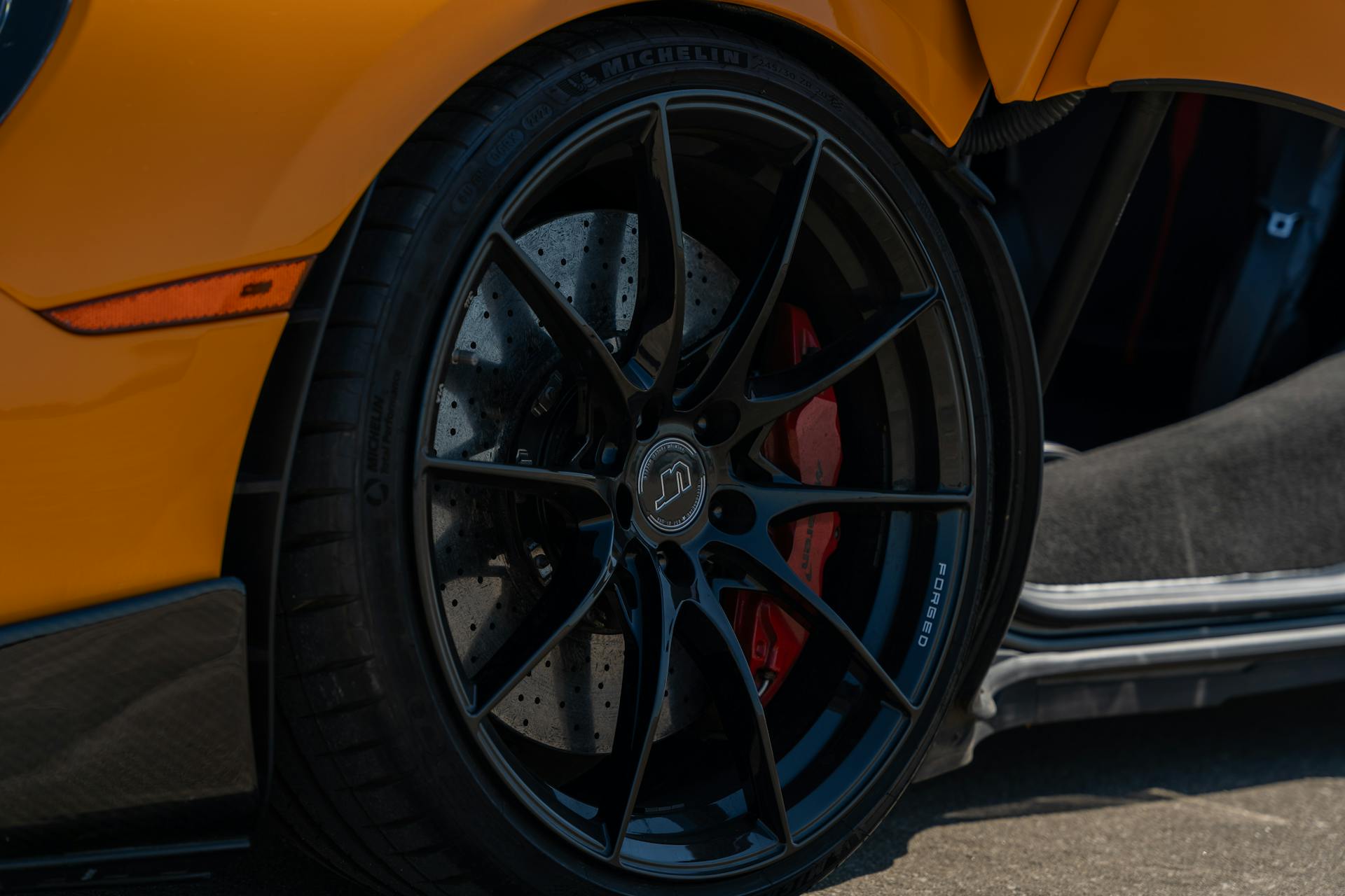 Detailed view of a black sports car wheel with carbon ceramic brakes in Illinois.