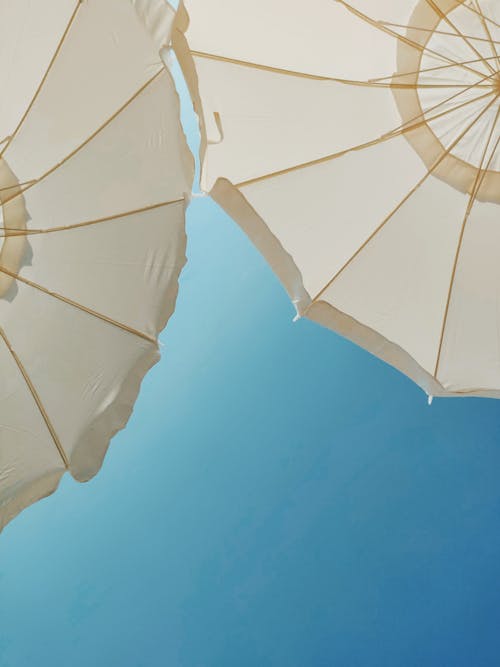 Low-Angle Photo of White Patio Umbrellas