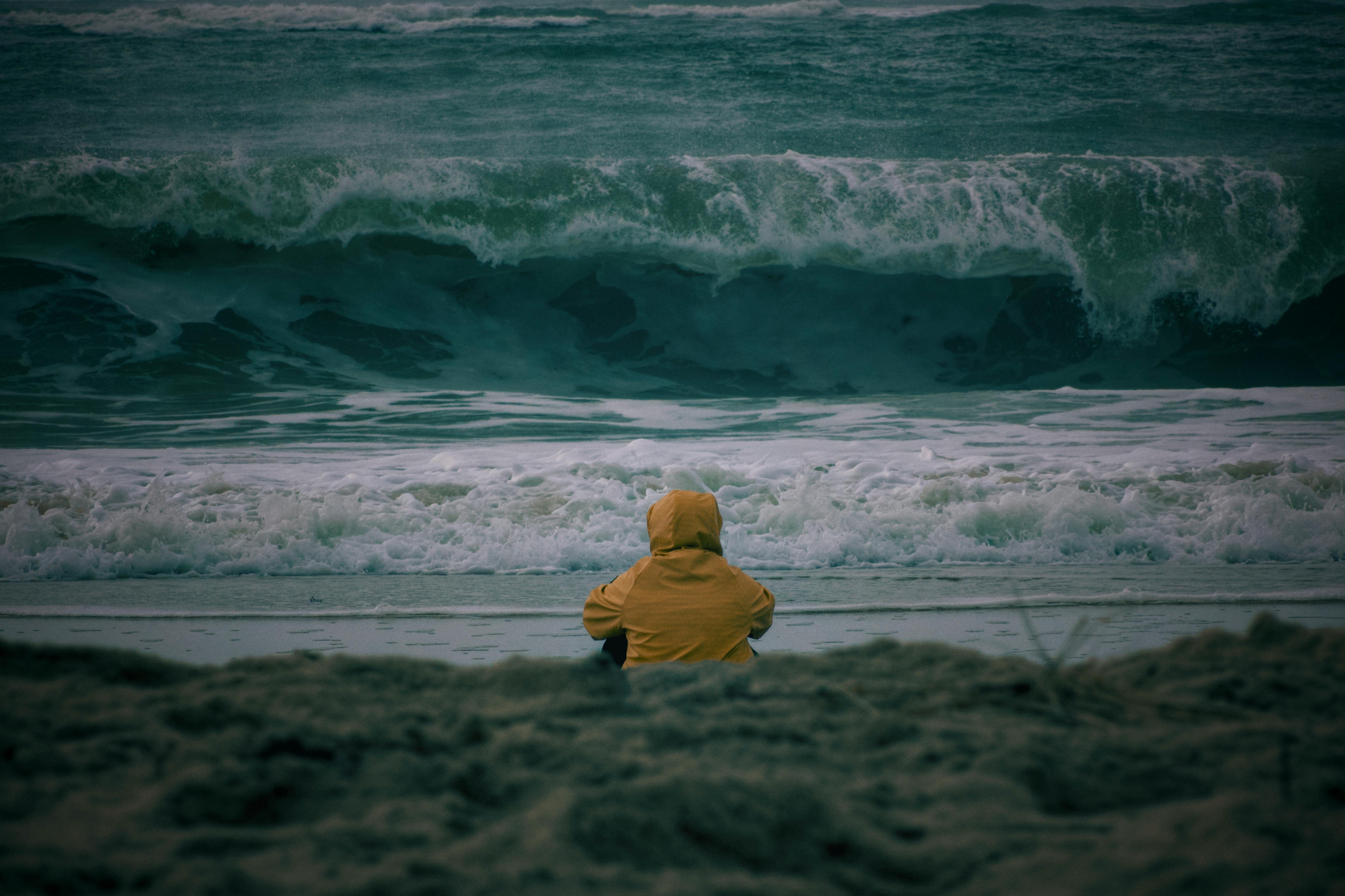 solitary figure facing the atlantic ocean waves