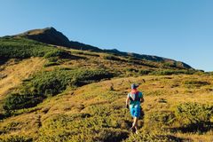 A runner enjoys a sunny day on a scenic mountain trail, showcasing outdoor adventure and nature.