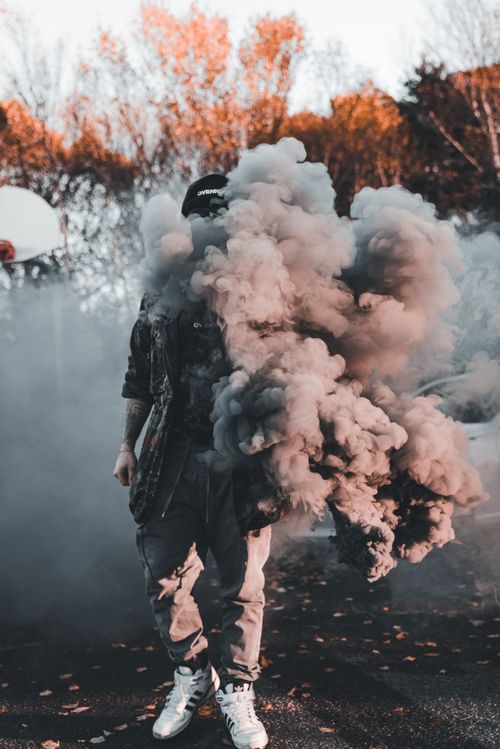 Free A person obscured by dense smoke outdoors in an autumn setting. Stock Photo