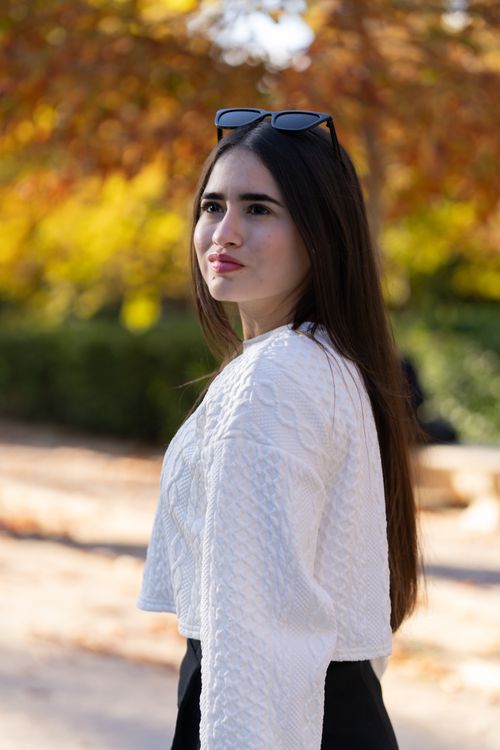 Free Portrait of a young woman in a white sweater outdoors in autumn. Stock Photo