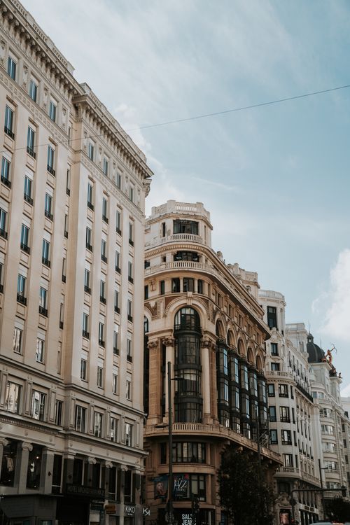 Free Classic architectural buildings on a vibrant Madrid street against a bright blue sky. Stock Photo