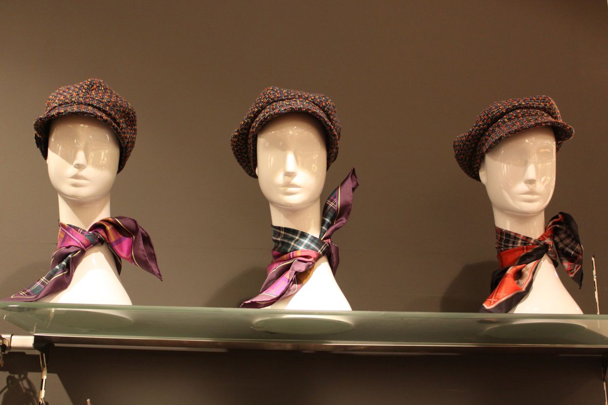 Hats and silk scarves styled on mannequin heads in a shop window — photo by Almir reis on Pexels