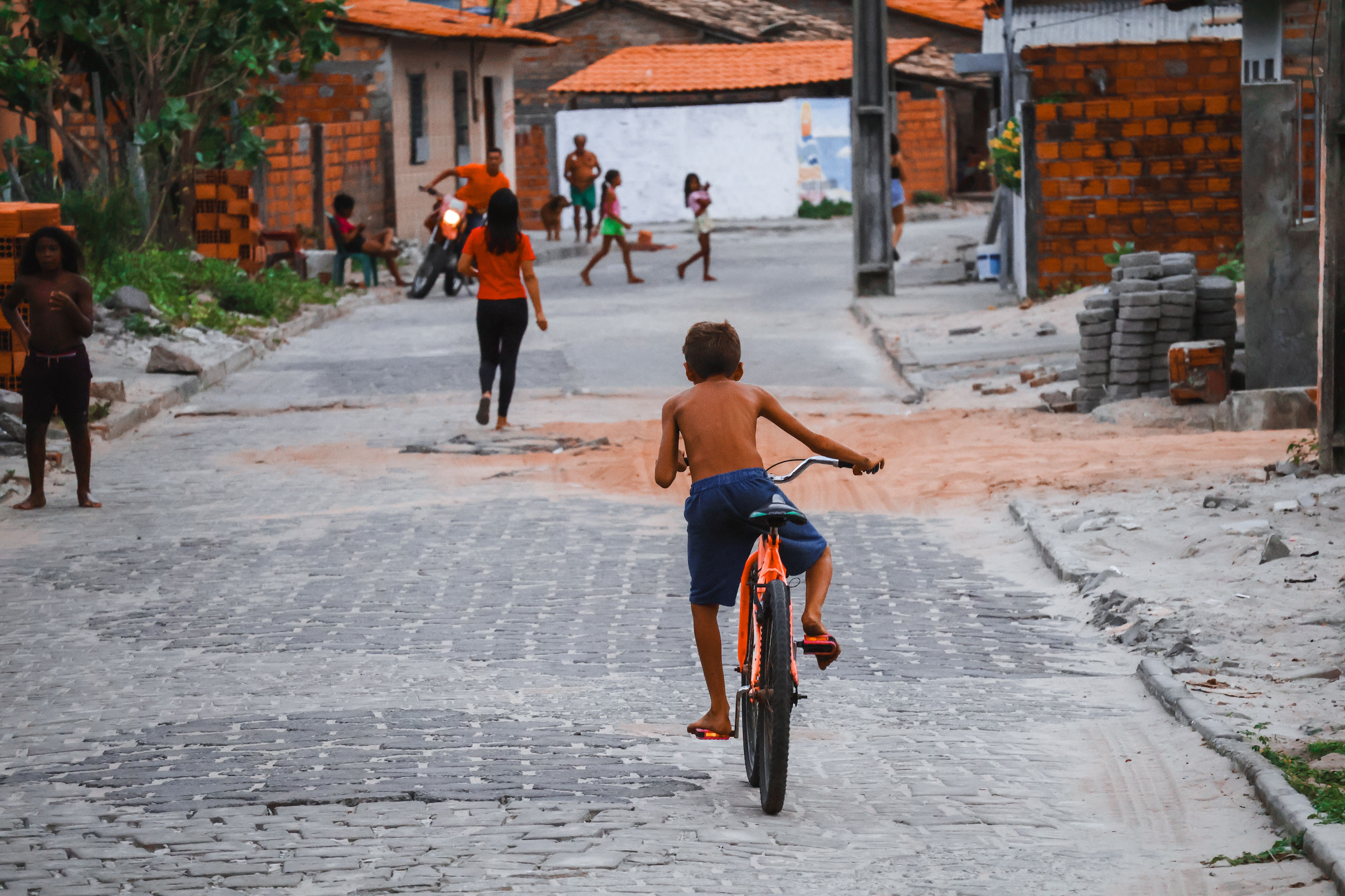 A kid rides a bike through Santo Amaro village in Maranhão, Brazil, capturing rural life.