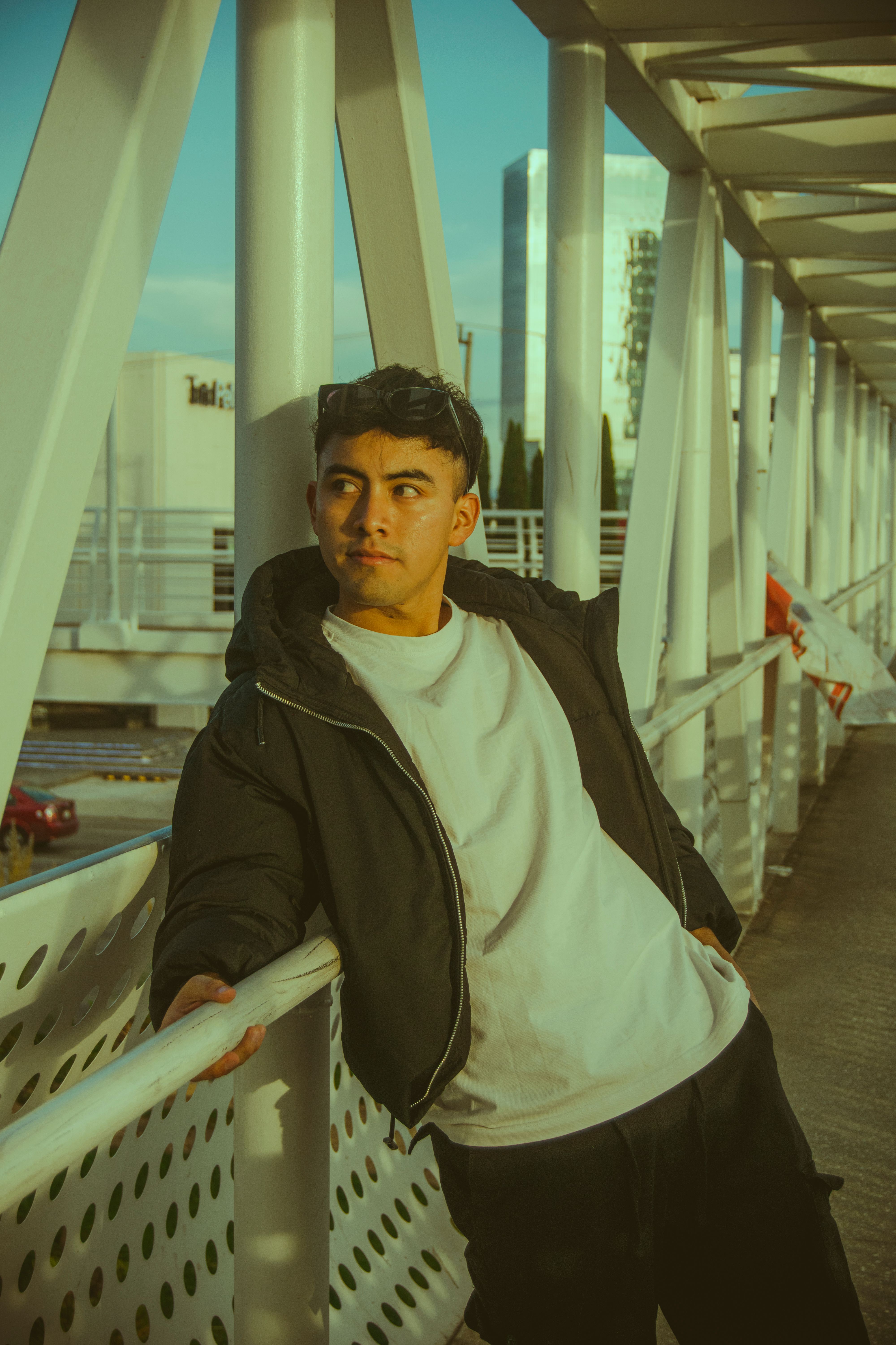 Young Man on Urban Bridge at Dusk · Free Stock Photo