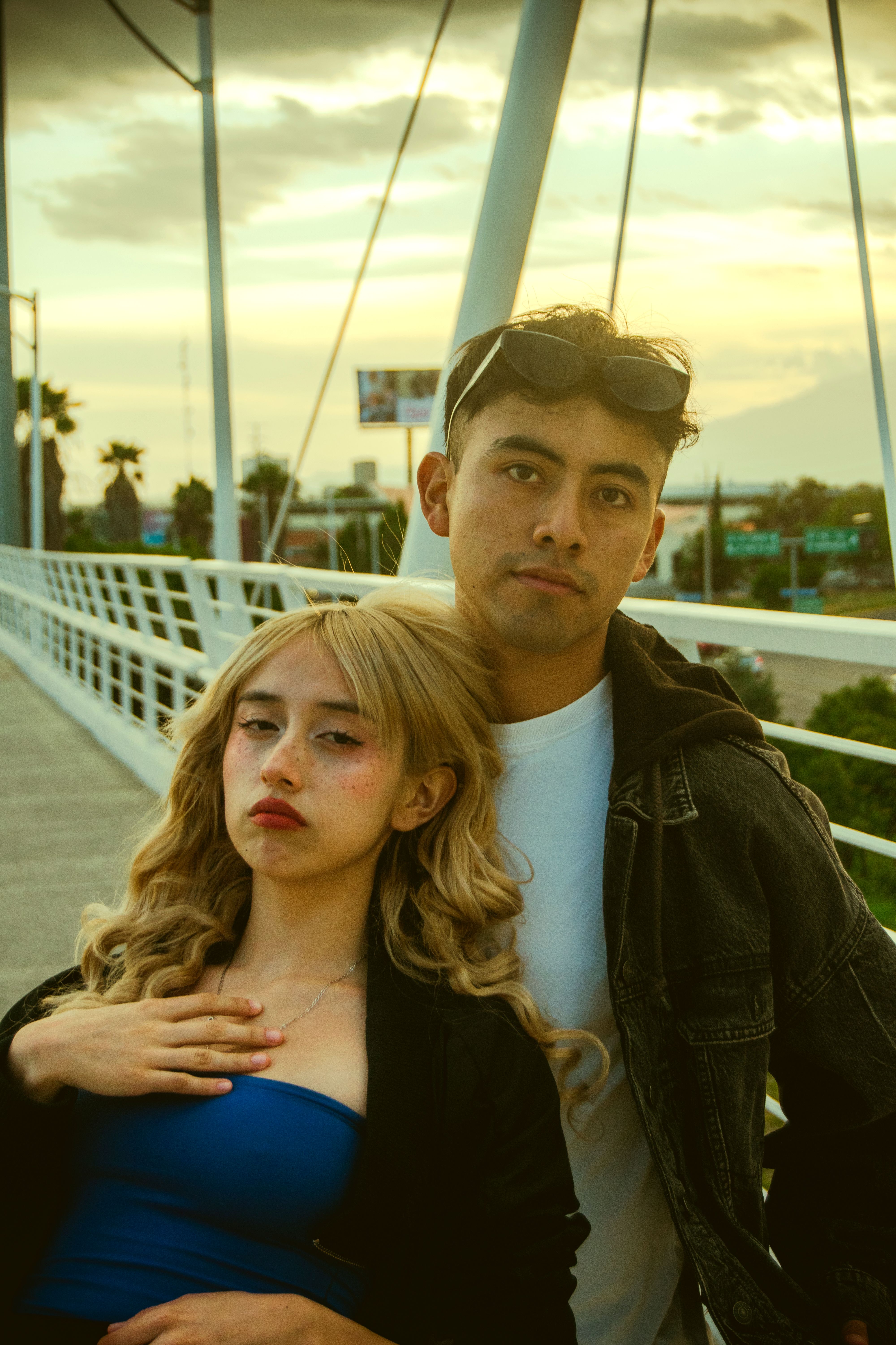 Young Couple Posing on Urban Bridge at Sunset · Free Stock Photo