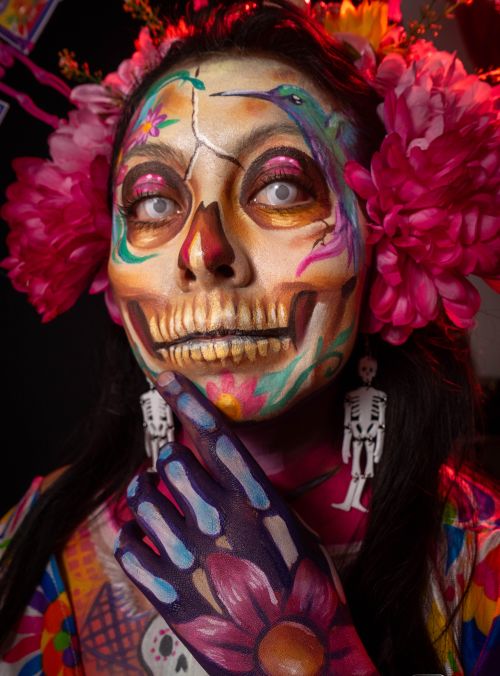 Free Colorful Catrina face paint depicting traditional Day of the Dead art and vibrant floral headdress. Stock Photo