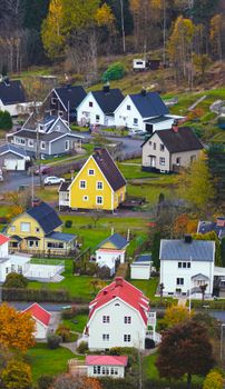 A picturesque Scandinavian village with colorful houses surrounded by fall foliage.