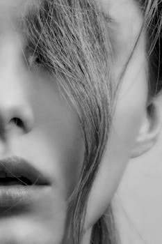 这是一幅黑白特写肖像，画中女子秀发垂面，尽显优雅与神秘