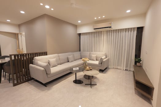 Spacious living room with gray sofa, coffee table, and ambient lighting in a modern minimalist design.