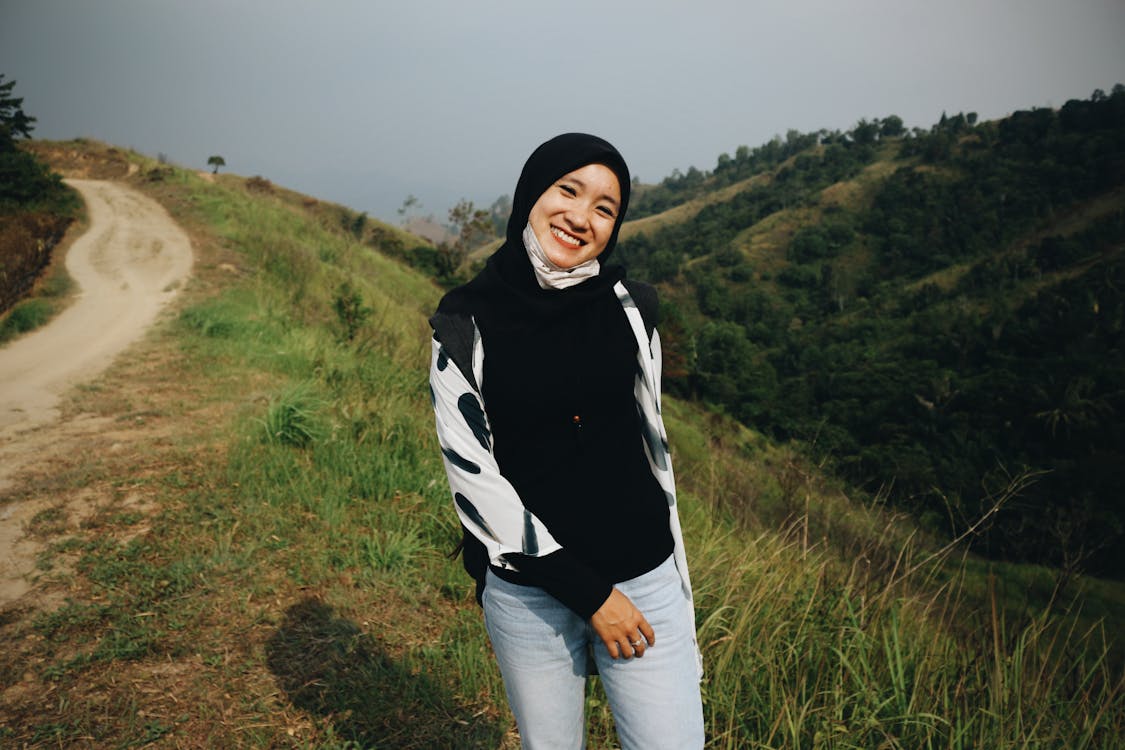 Free Photo of Smiling Woman in Black Hijab Posing by Dirt Road Stock Photo