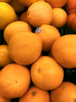 A vibrant collection of fresh oranges piled together, ripe for picking.