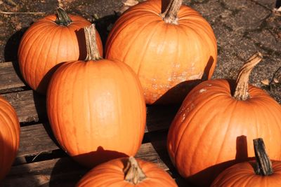 A group of bright orange pumpkins on a wooden surface