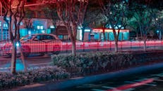 城市夜景充满活力，过往车辆划出绚烂的光轨，映衬着明亮的都市景观