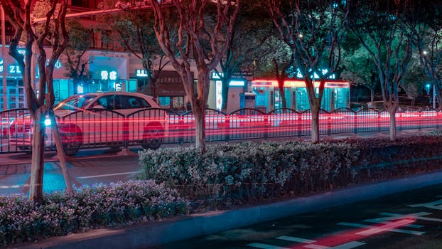 城市夜景充满活力，过往车辆划出绚烂的光轨，映衬着明亮的都市景观