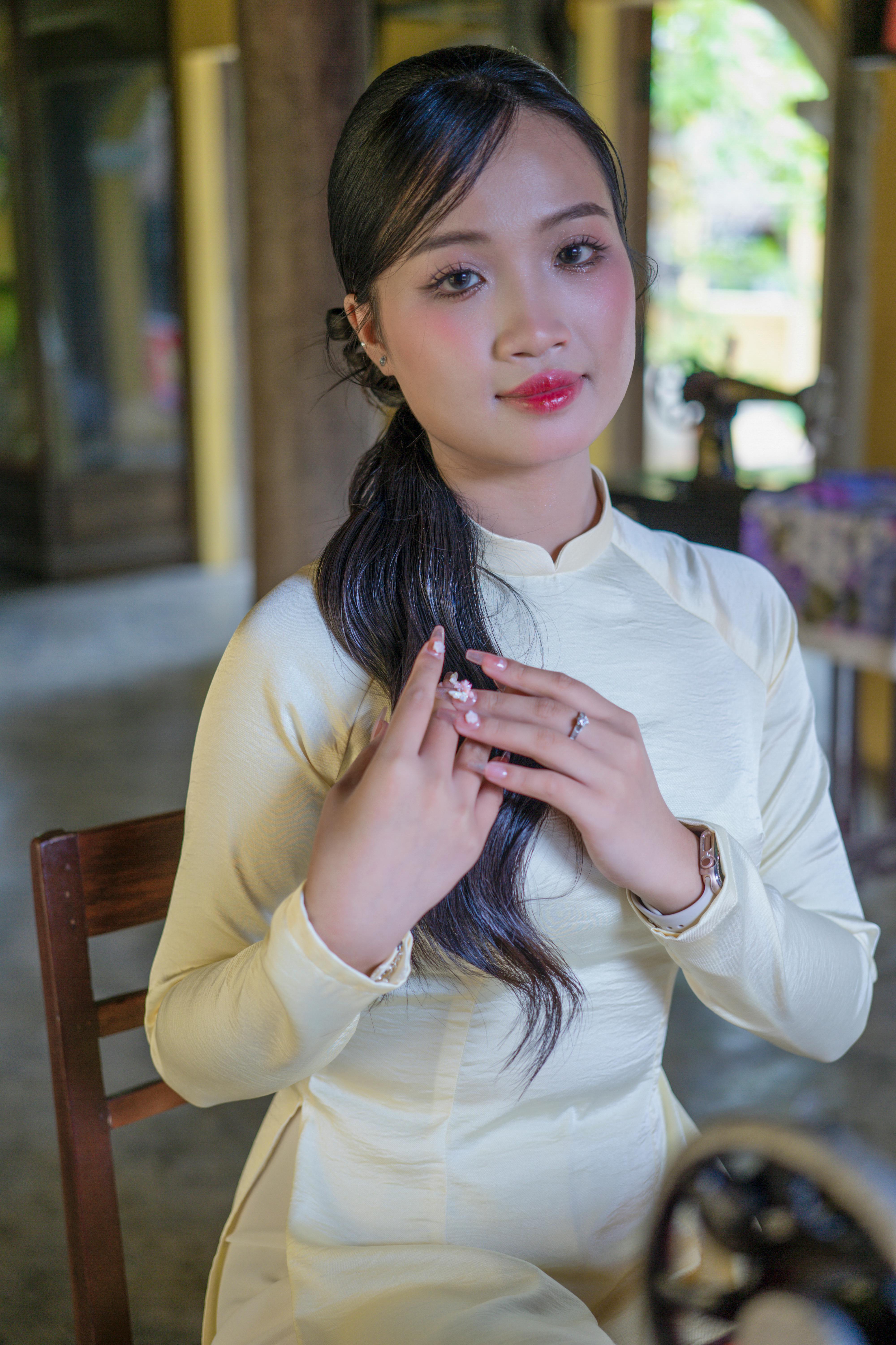 Portrait of a young woman in a traditional yellow dress indoors.