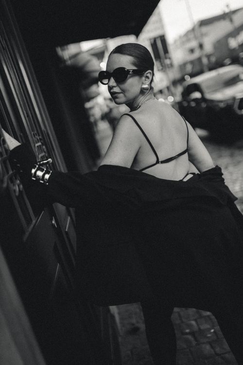 Free Stylish woman in black and white outfit on Brazilian street. Elegant, mysterious, fashion-forward style. Stock Photo