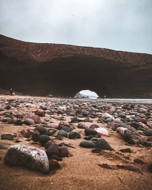 Free Capture of the stunning rock formations and pebbled shoreline of Legzira Beach in Morocco. Stock Photo