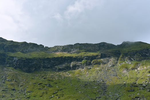 山间多云，风景秀丽，绿坡与岩地相映