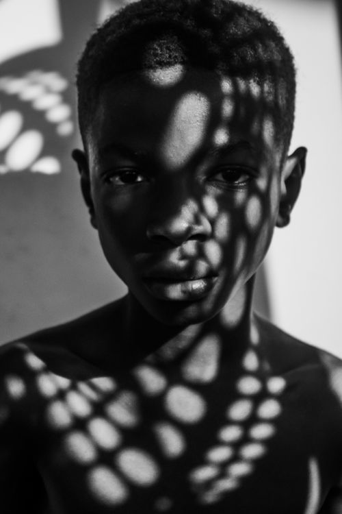 Free Black and white portrait of a young man with dramatic shadow effects on his face and body. Stock Photo