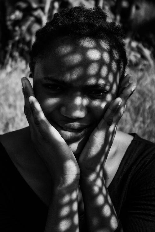 Free Black and white portrait of a woman with patterned shadows on her face. Stock Photo